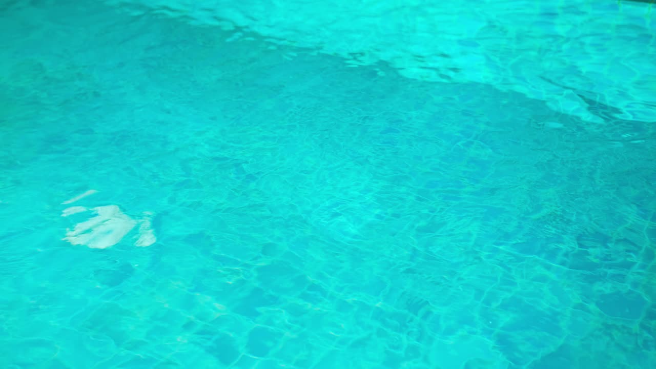 Pemandangan atas tekstur air biru di kolam renang.