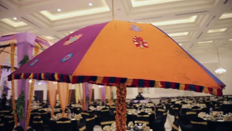 an umbrella close up rotational view in the wedding party, showing decoration, hall, dinner setup and sitting arrangement