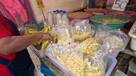 person packaging bamboo shoots for market sale.