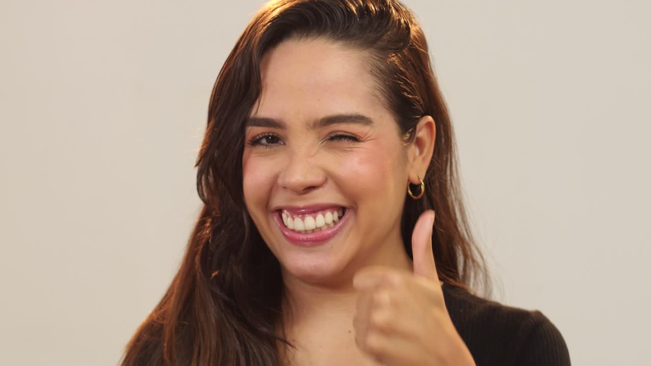 cerca de una mujer joven con los pulgares hacia arriba