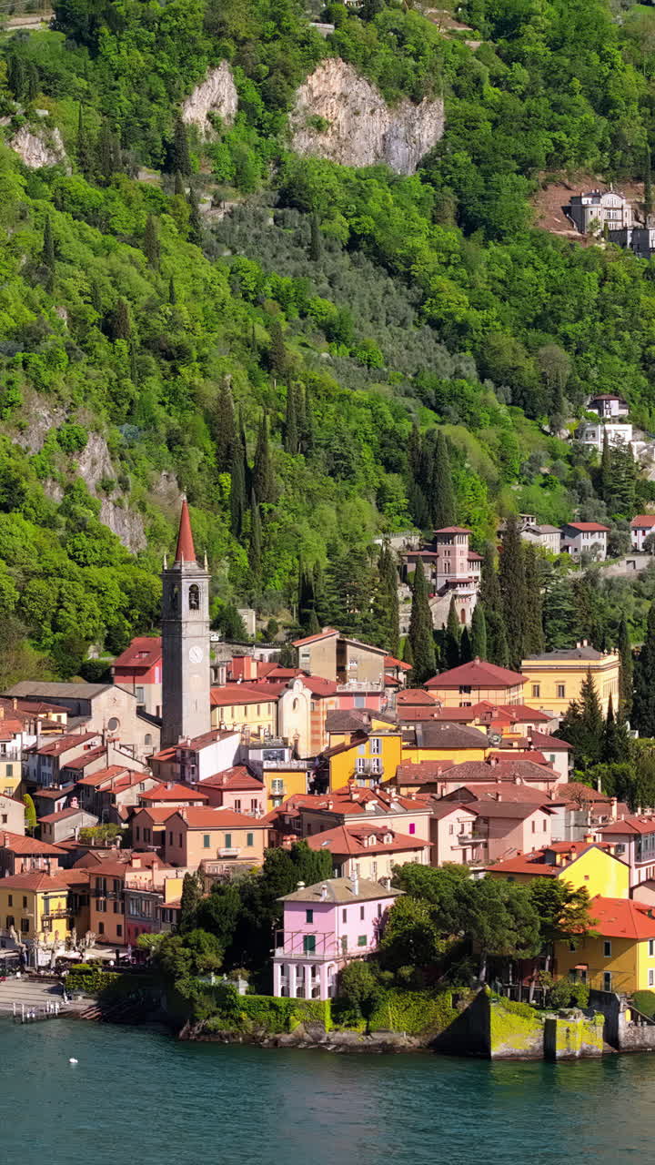 Aerial drone view of Church of S.Giorgio surrounded by houses in Varenna, Italy. Vertical