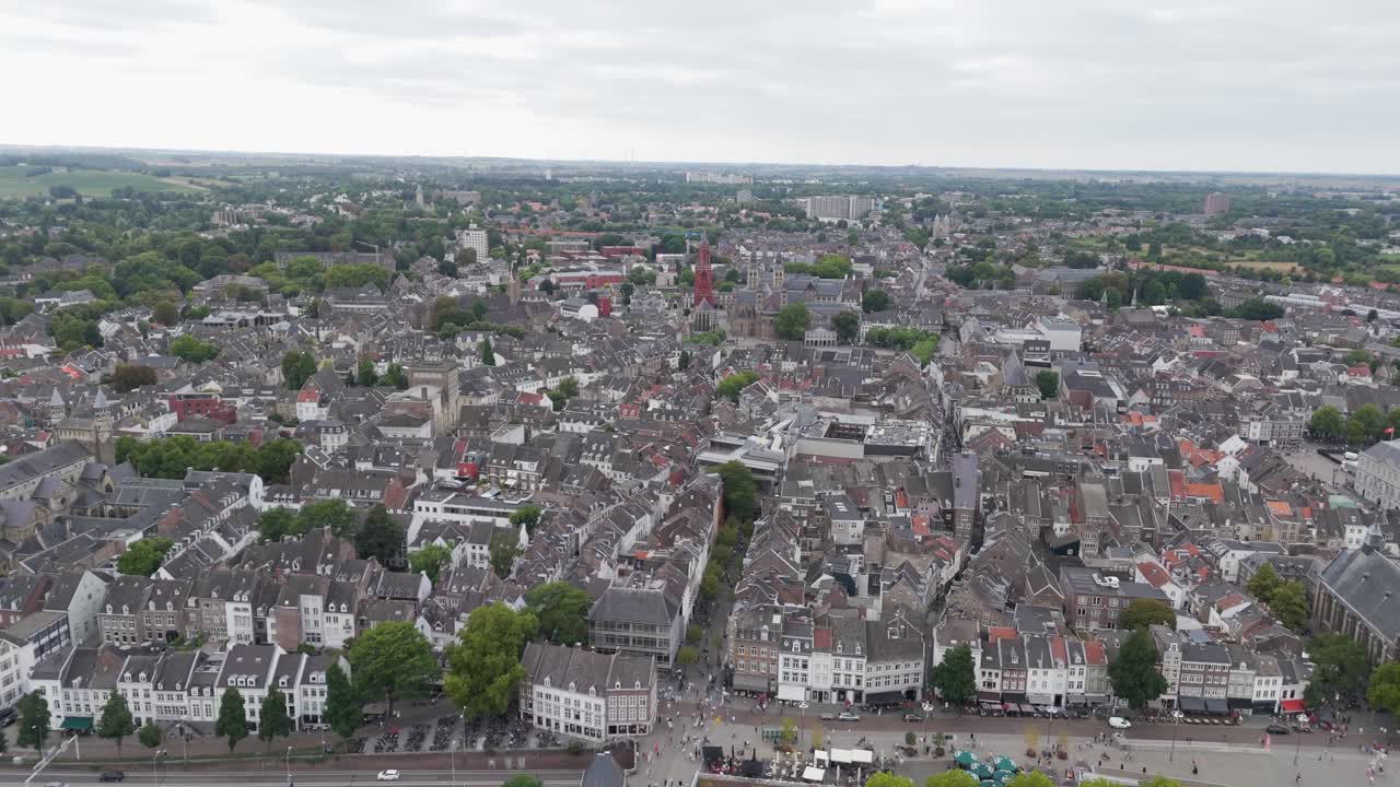 Drone footage of Maastricht in the Netherlands, featuring the River Maas and the historic Sint Servaasbrug, surrounded by old European architecture