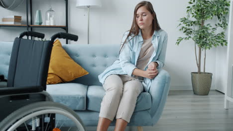 woman sitting on sofa with wheelchair
