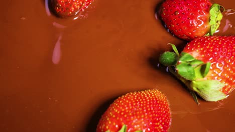 strawberries being dipped in melted chocolate