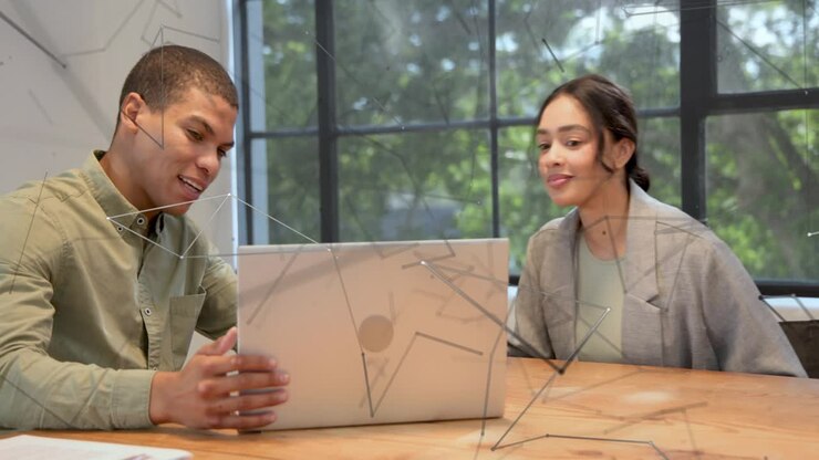 Colleagues initiating handshake, man navigating laptop tilting screen showing report for business