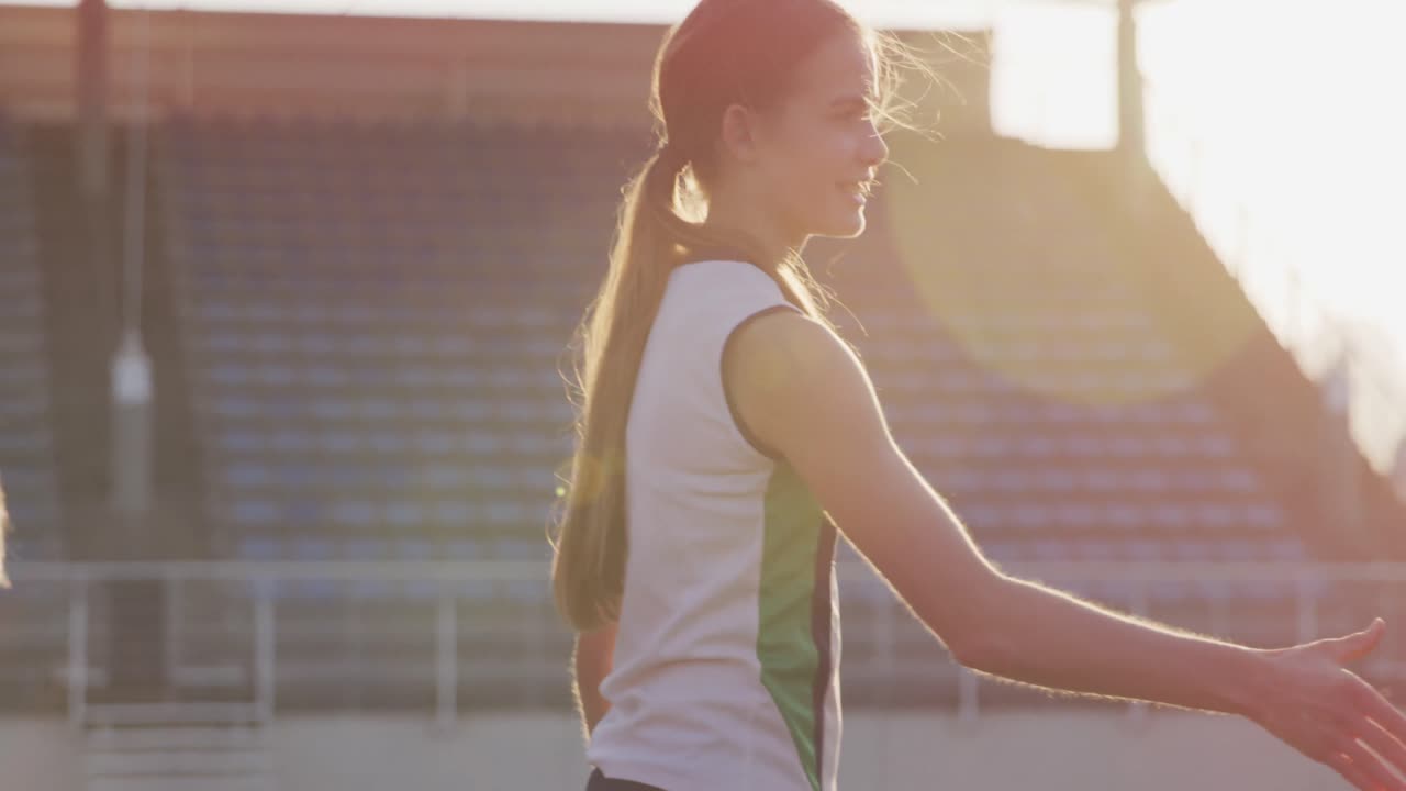 여자 하키 선수 들 이 경기장 에서 서로 손을 흔들고 있다