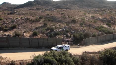 un vehículo sube por una carretera bordeada por una valla alta