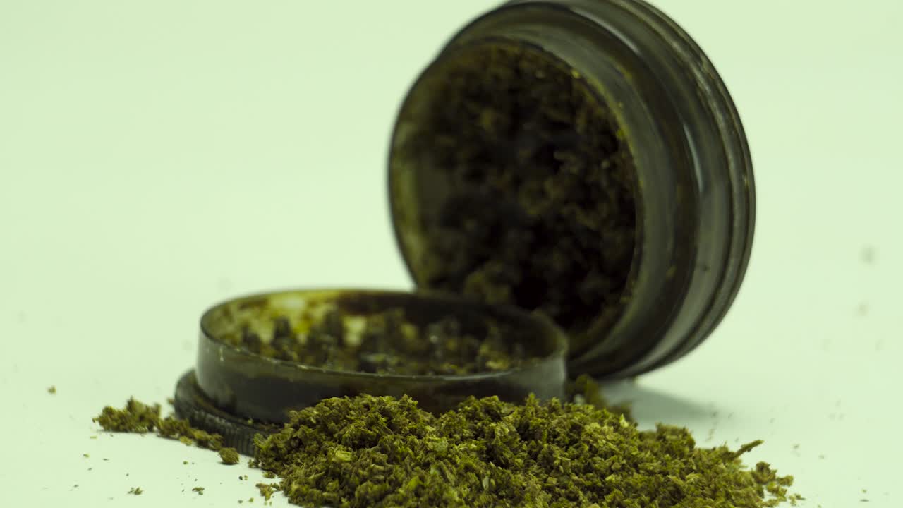 picking grinded weed to pack in a bowl