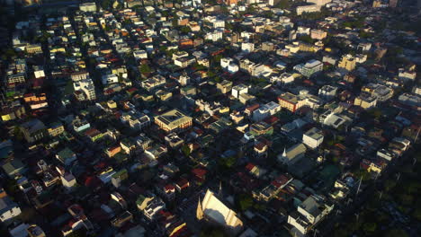 Descripción-Aérea-De-Viviendas-Iluminadas-Por-El-Sol-En-El-Barangay-De-Olympia-En-Manila,-Filipinas