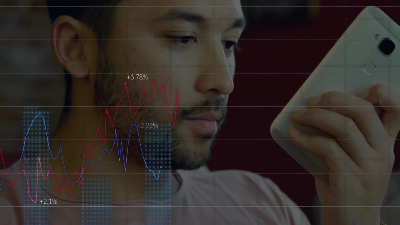 Man bringing phone near mouth, holding and tilting, speaking while charts filling for market review