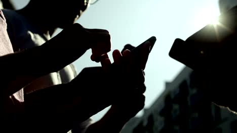 vista de abajo de los jóvenes que usan teléfonos inteligentes.