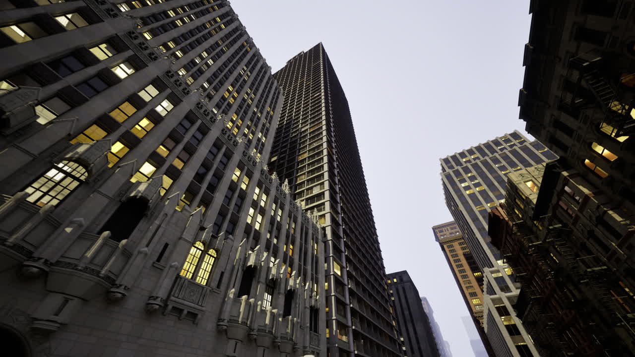 Tall skyscrapers illuminated at dusk in an urban city environment