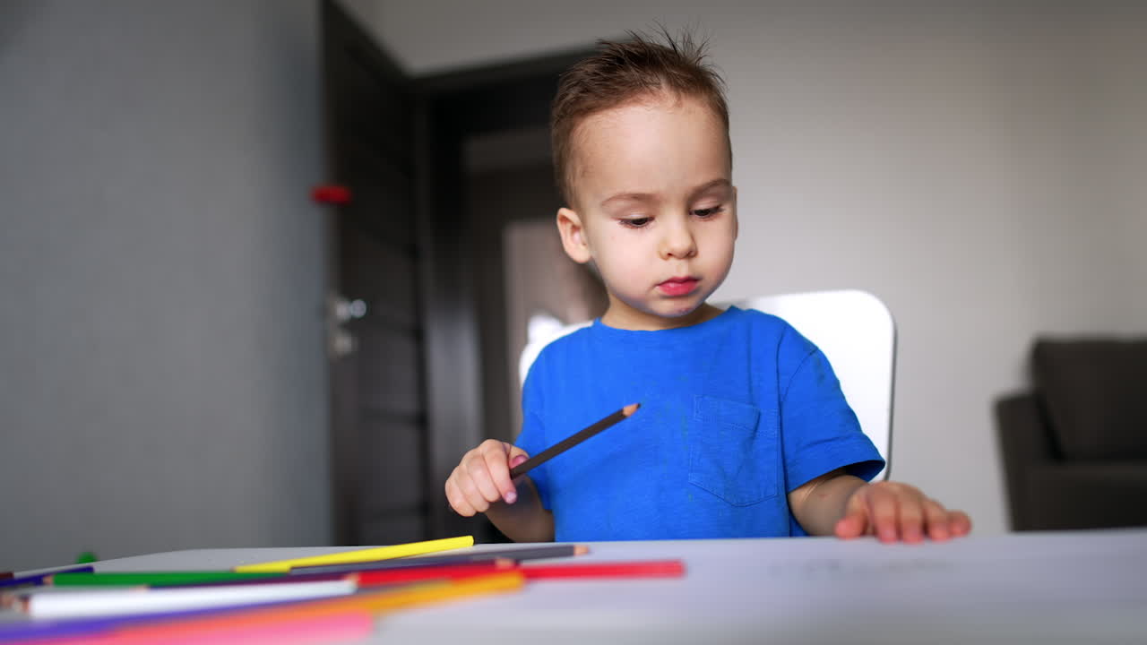 Lindo niño juguetón pintando con lápices. Concepto de niño pequeño y lindo dibujando.