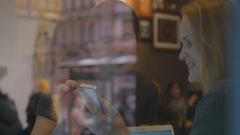 Woman-and-man-have-a-discussion-in-the-restaurant-using-smartpho