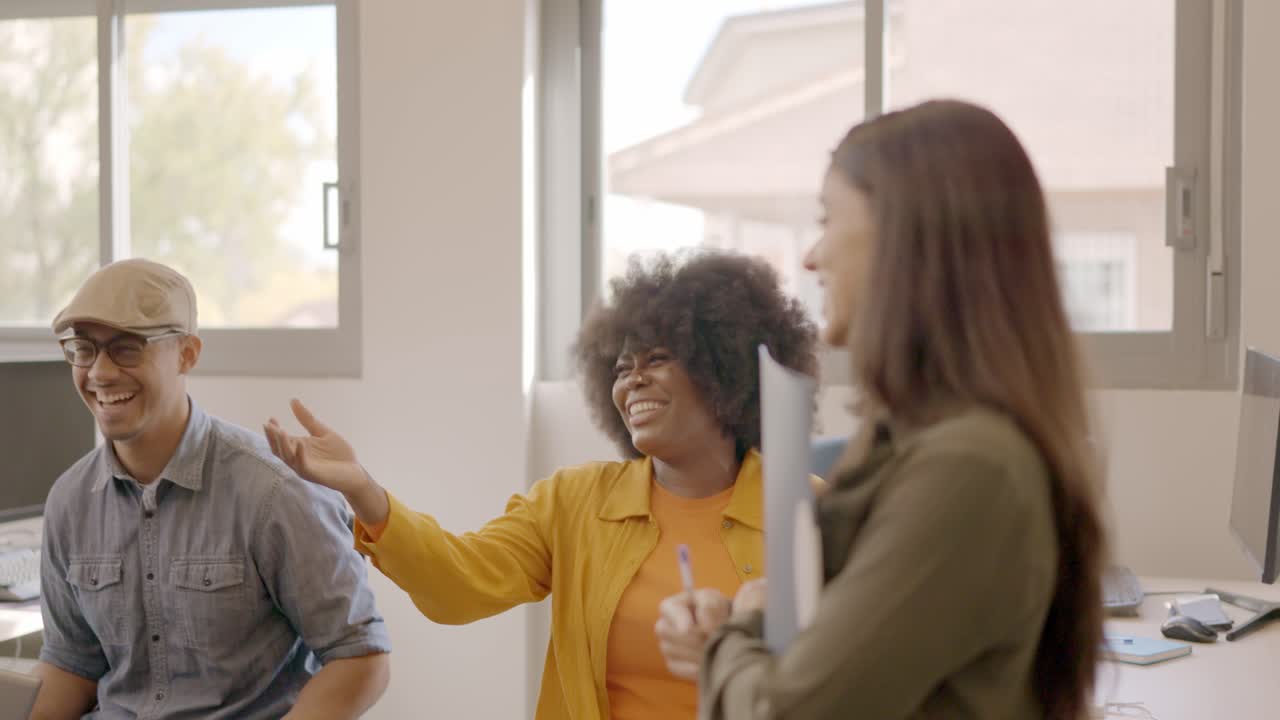 Happy coworking collegues laughing in a meeting