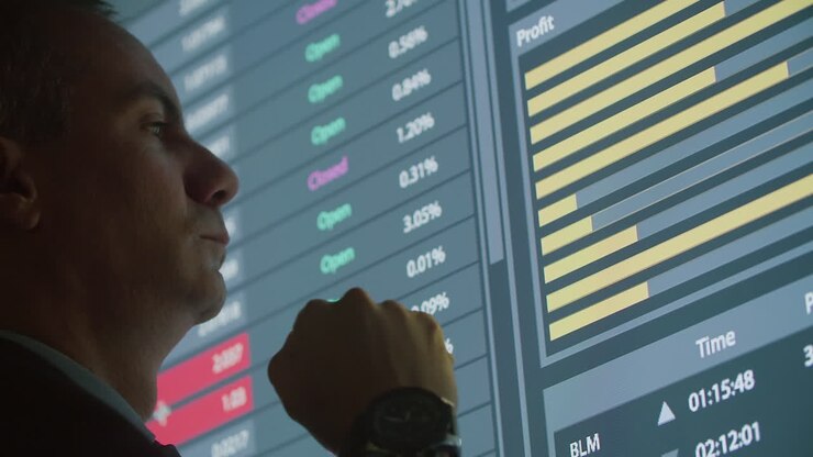 Uomo pensieroso che guarda grafici a barre su un grande schermo digitale