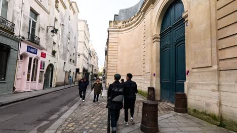 two people walking down a cobblestone street