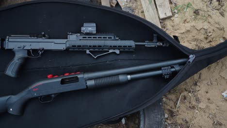 shotgun and tactical assault rifle in black open bag, olesko shooting range