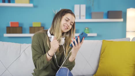 una joven feliz usando el teléfono mientras baila.