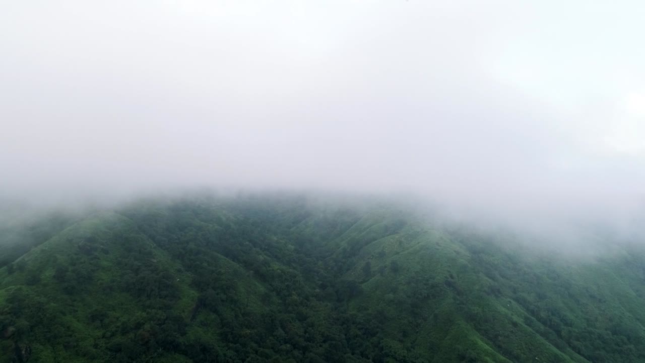 인도의 가을철 마지막 비가 내린 후 무성한 숲으로 산 꼭대기를 덮고 있는 짙은 안개