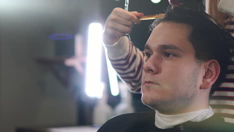 Close-up-of-men's-hair-cutting-scissors-in-a-beauty-salon.-Frame.-Close-up-of-a-haircut-at-a-hair-saloon.-Professional-barber-styling-hair-of-his-client