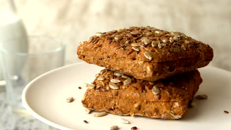 two delicious homemade small loafs of bread with seeds. milk-jug, on wooden rustic table. looped