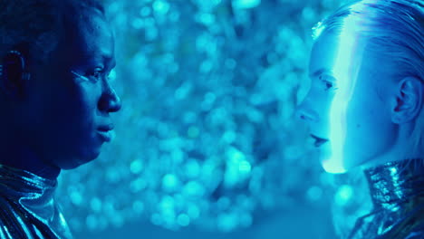 side view of male and female aliens in blue laser light