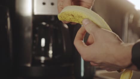 hand peeling ripe banana in the kitchen for smoothie