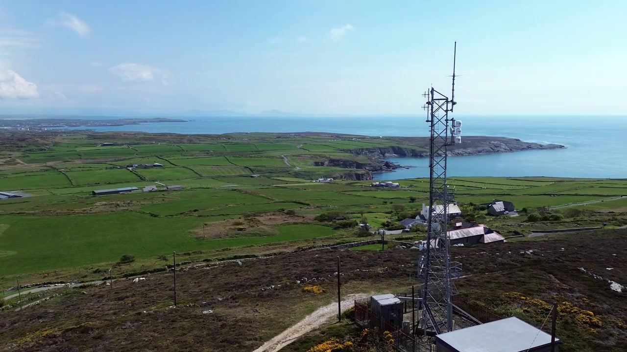 Telekommunikationstårn med udsigt over Holyheads landbrugskystlinje, kredsende luftfoto
