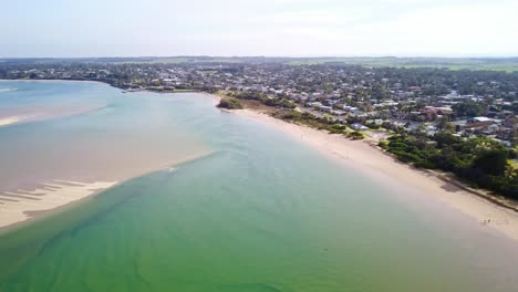 Aerial-footage-over-the-ocean-approaching-the-town-of-Inverloch,-Victoria,-Australia