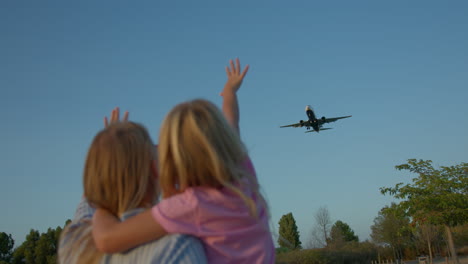 family waves goodbye to airplane