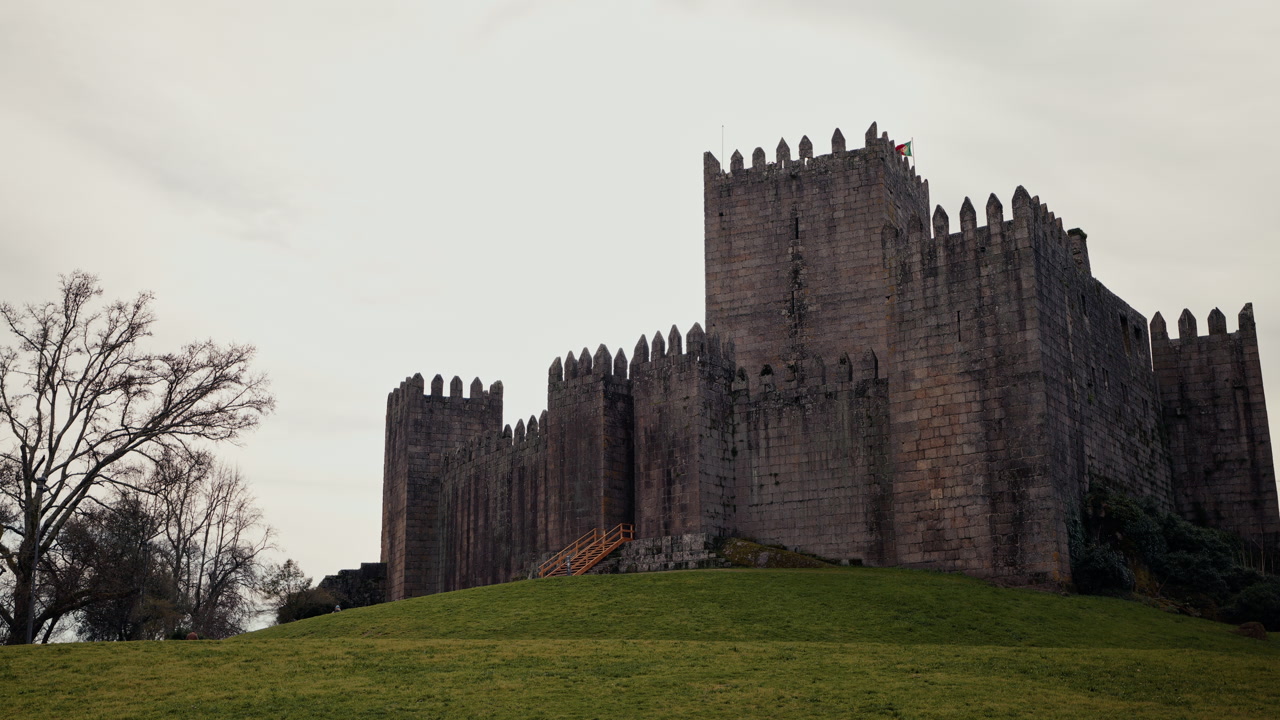 The imposing medieval Castelo de Guimarães rises above the historic town in Portugal, its square towers and granite stone walls standing as a symbol of the founding of the Portuguese nation.
