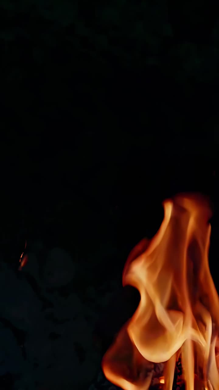 Close-up video of swirling flames against a dark background, capturing dynamic movement and glowing