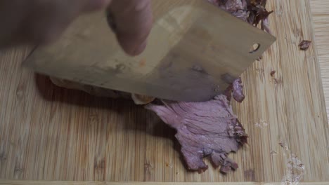rebanar cordero asado en el hueso con cuchilla, jugoso, dolly shot