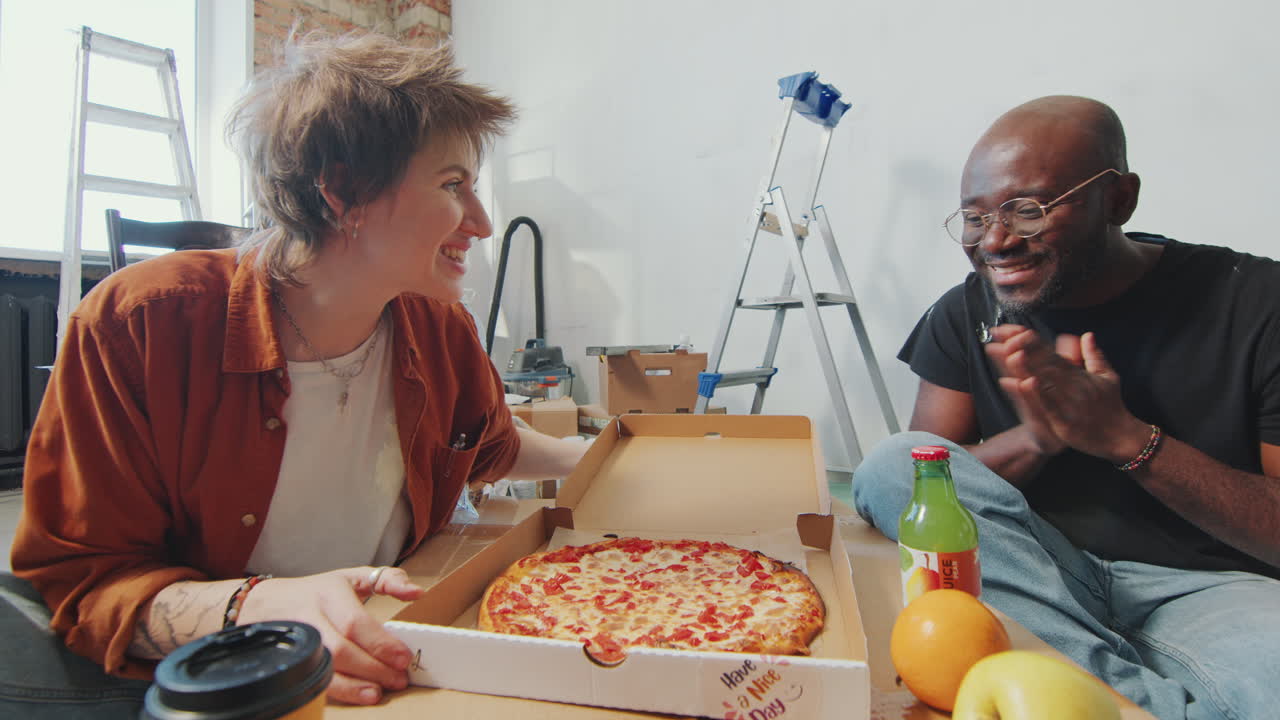 Cheerful Woman and Man Going to Eat Pizza in Room under Renovation