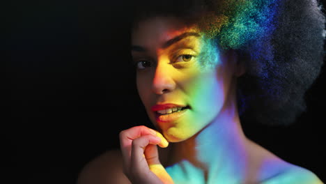 retrato multicolor mujer hermosa con afro funky sonriendo segura disfrutando de la expresión individual belleza femenina natural luz colorida sobre fondo negro concepto de orgullo lgbt