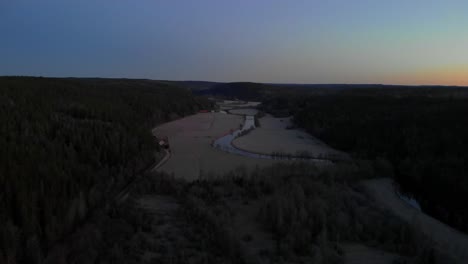 Toma-Aérea-Del-Hermoso-Paisaje-Natural-En-Suecia-Al-Amanecer,-Río-Que-Fluye-En-El-Bosque-Boreal