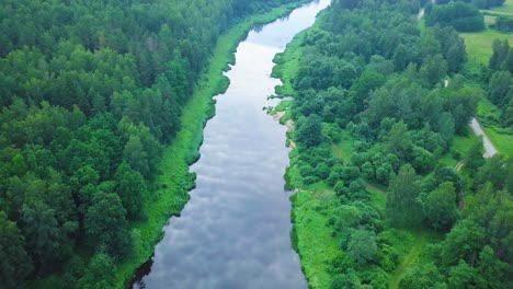 Vista-Aérea-De-Pájaro-De-Un-Río-Venta-En-Un-Día-Soleado-De-Verano,-Exuberantes-árboles-Y-Prados-Verdes,-Hermoso-Paisaje-Rural,-Disparo-De-Drones-De-Gran-Angular-Moviéndose-Hacia-Atrás