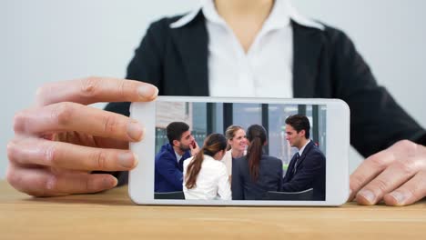 Mujer-Usando-El-Teléfono-Con-Una-Reunión-De-Negocios