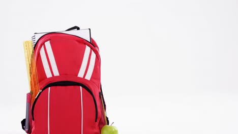 bolso de escuela rojo y manzana sobre fondo blanco