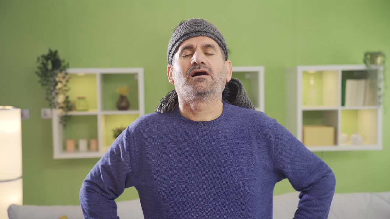 un anciano maduro tiene rigidez en el cuello y dolor mientras hace ejercicios deportivos en casa.