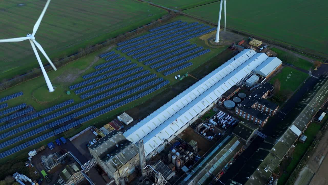 Onsite green power drone shot of a King's Lynn industrial facility showcasing hybrid wind and solar infrastructure for sustainable production