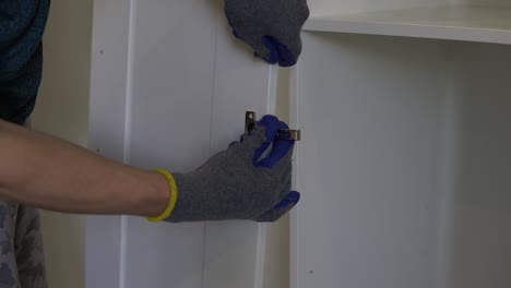 installs the door hinge on the cabinet door