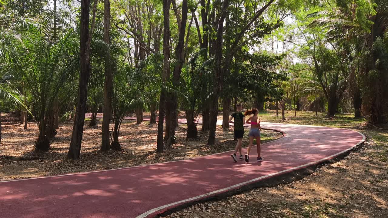 una pareja corriendo en un parque.