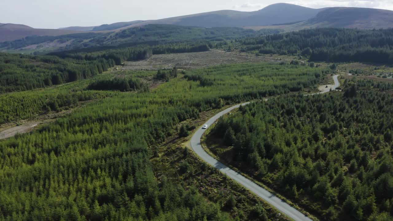 vista aérea de los coches que circulan por una larga y sinuosa carretera de montaña en las montañas de wicklow en un día soleado-5