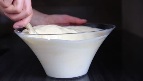 Woman-chief-mixing-mass-of-dough-with-wooden-spoon