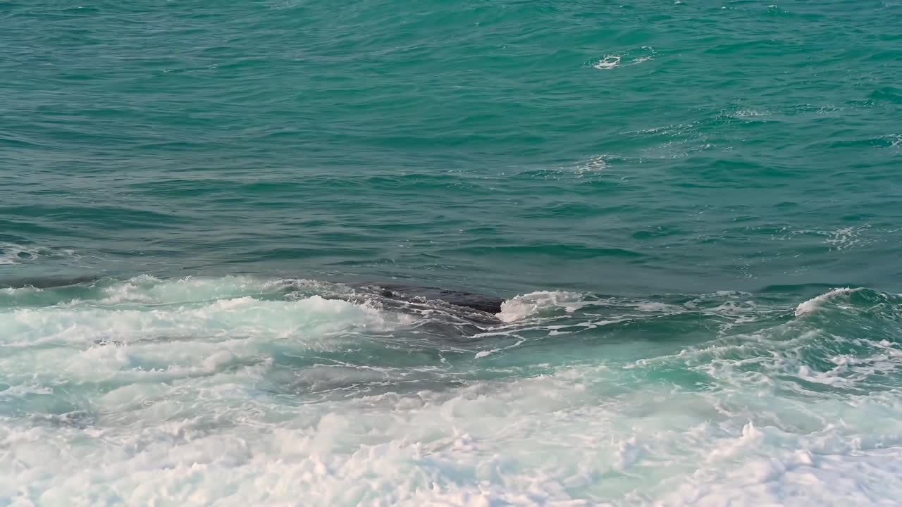 Waves hitting over rocks on the shore in Kyrenia, Girne, Cyprus