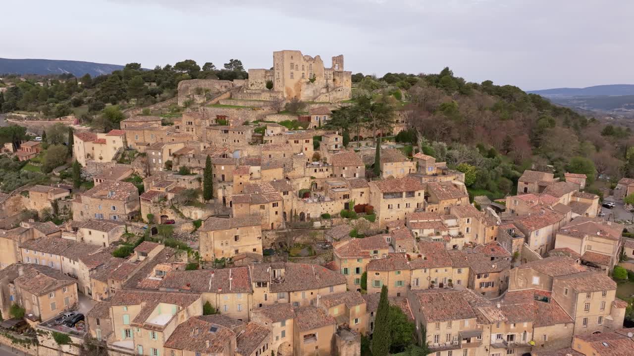 Vista aerea della medievale Lacoste e del suo castello bagnati dal sole mattutino, Provenza
