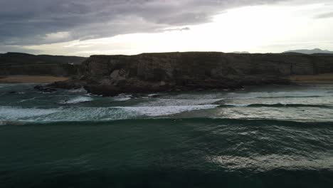 Two-surfers-sitting-on-surfboard-waiting-for-waves-at-ocean-cliff