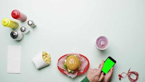 Draufsicht-Mann-Mit-Smartphone-Im-American-Diner-Fast-Food-Restaurant-Hände-Von-Oben---Roter-Epischer-Drache